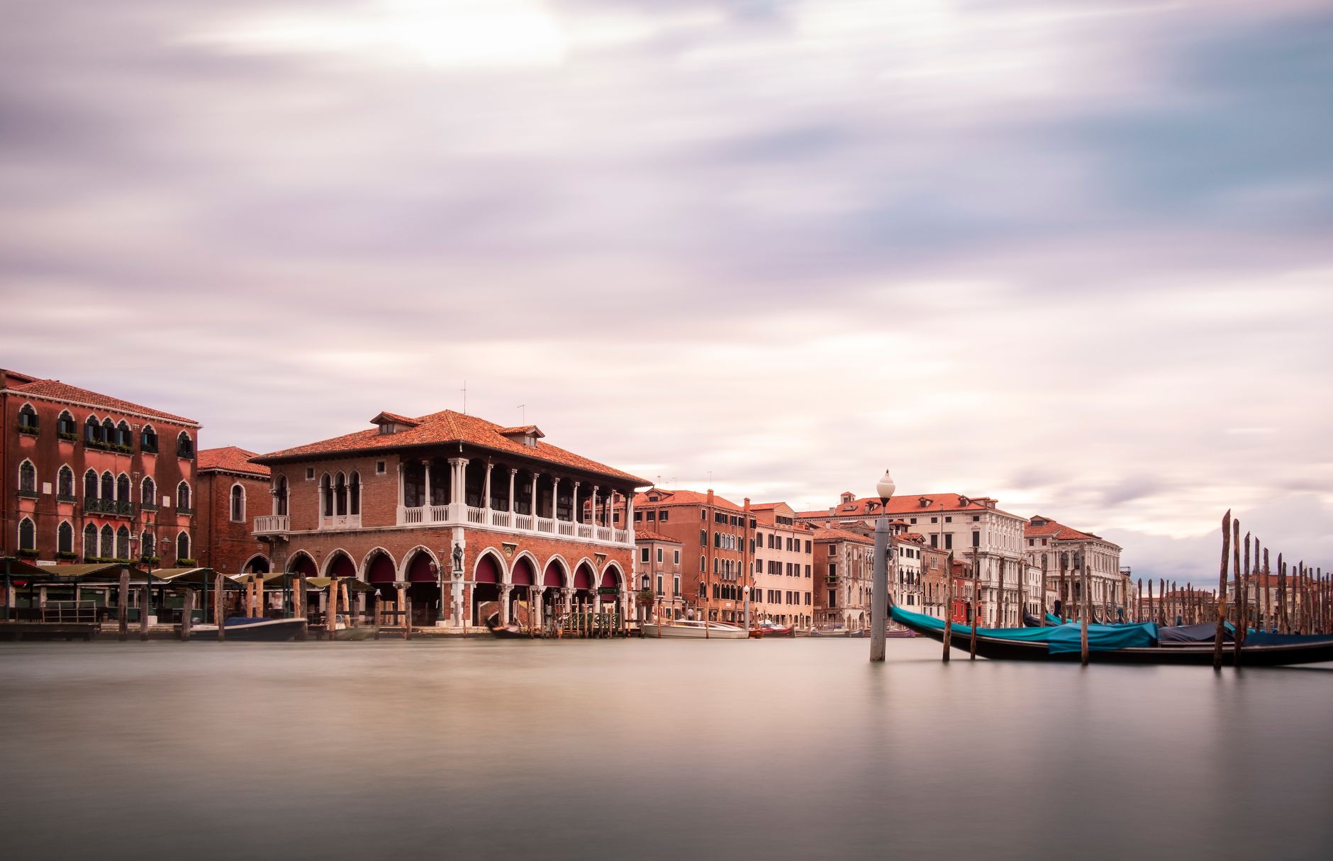 Canal Grande in Venice with traditional gondolas and historic architecture under a cloudy sky
