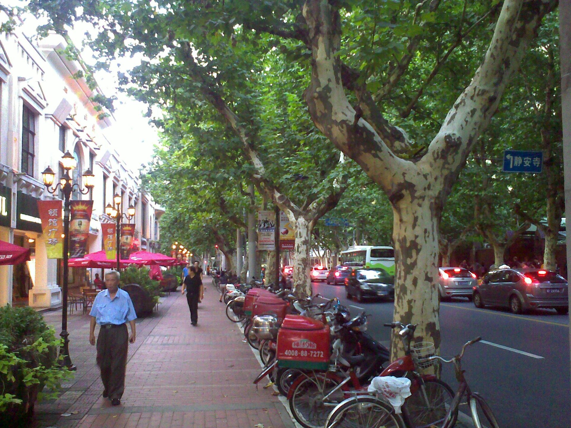 Hengshan Road under a full canopy of plane trees, with a cyclist passing
