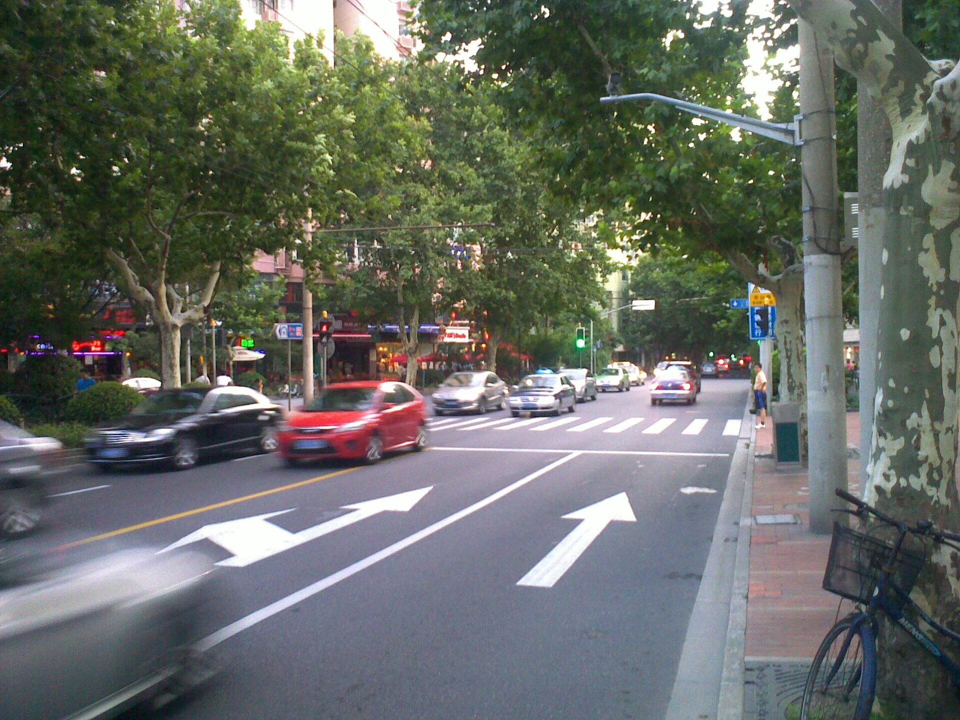 A wide tree-lined avenue in the former French Concession with traffic