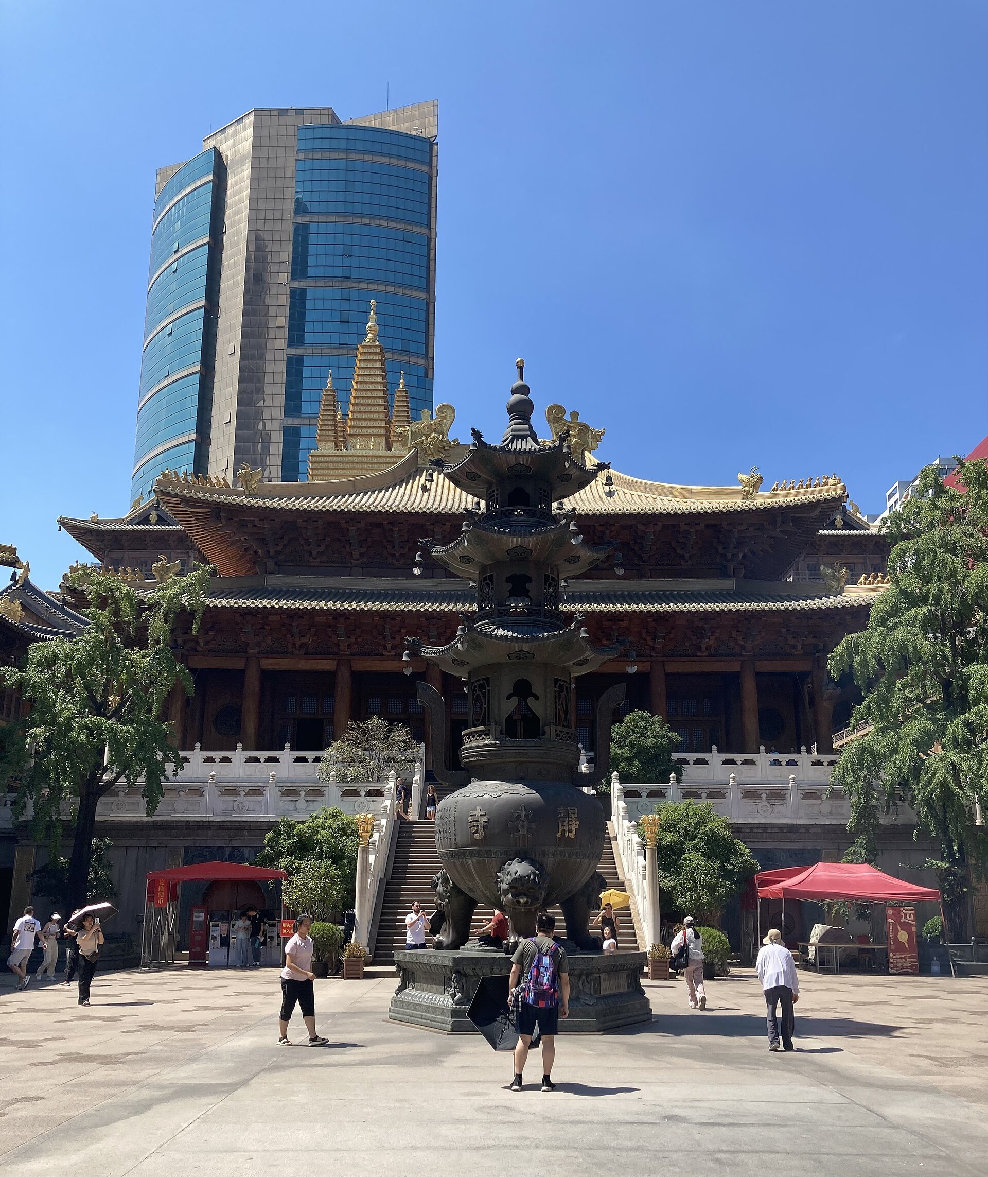 Visitors crossing the paved courtyard in front of the temple hall