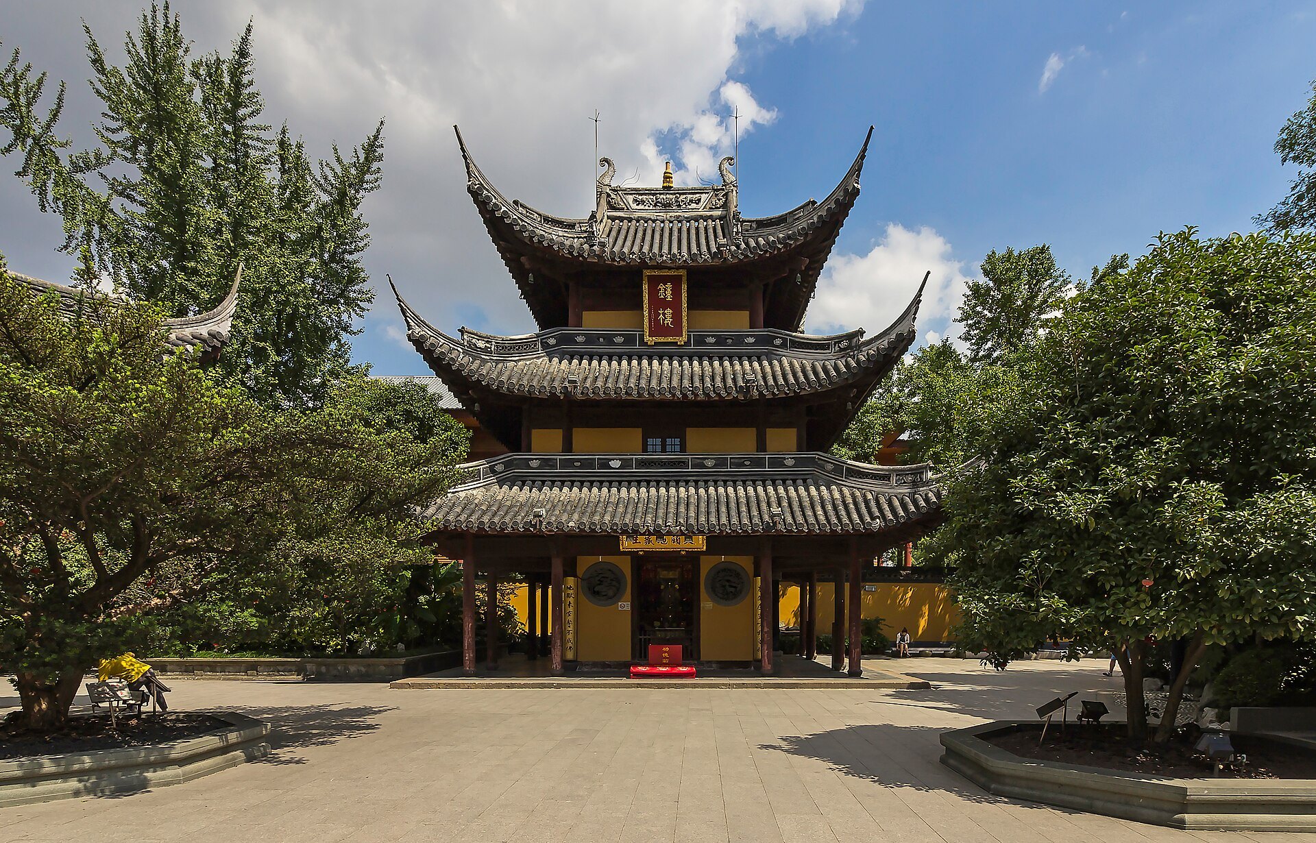 The main hall of Longhua Temple with trees and a clear sky behind