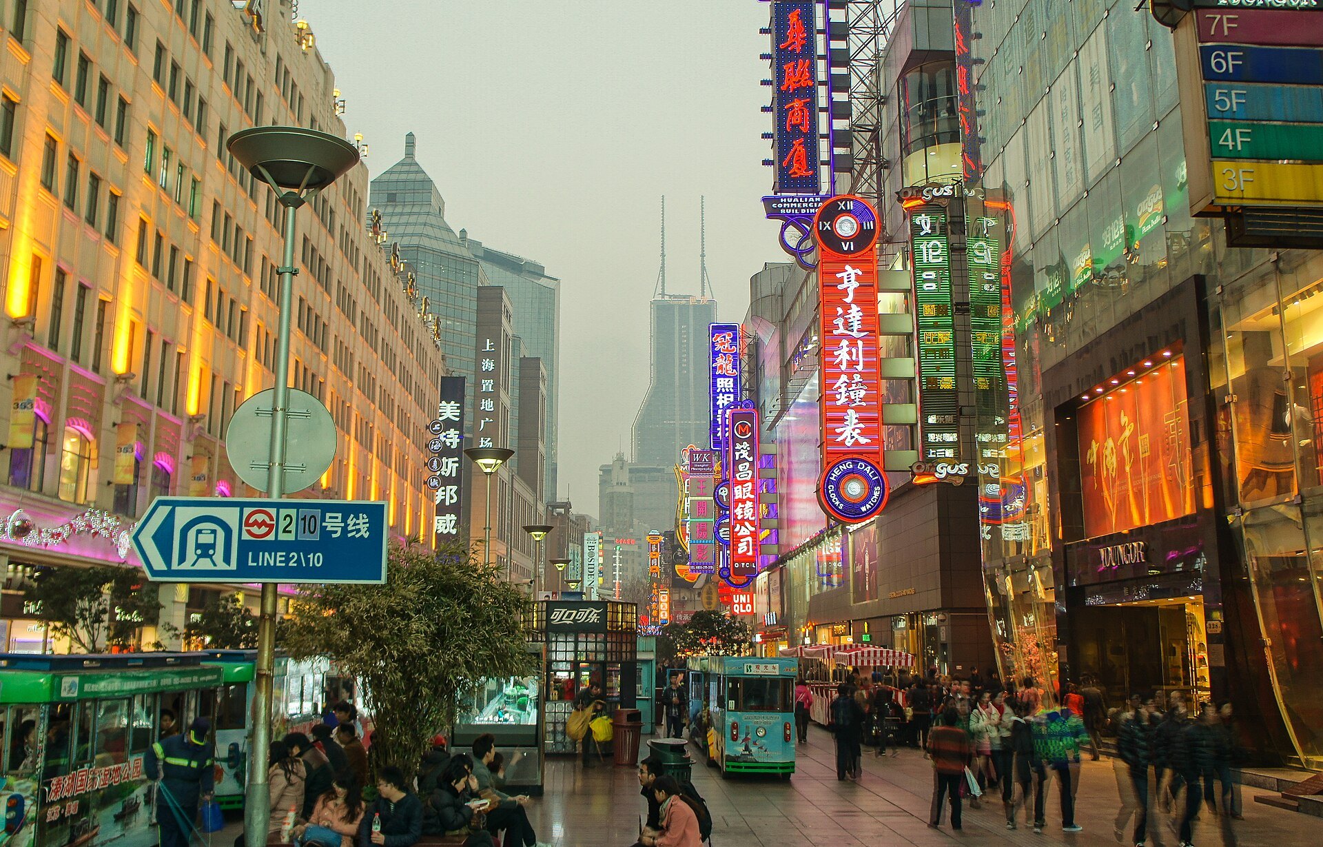 Nanjing Road at dusk with its illuminated signs above the crowd
