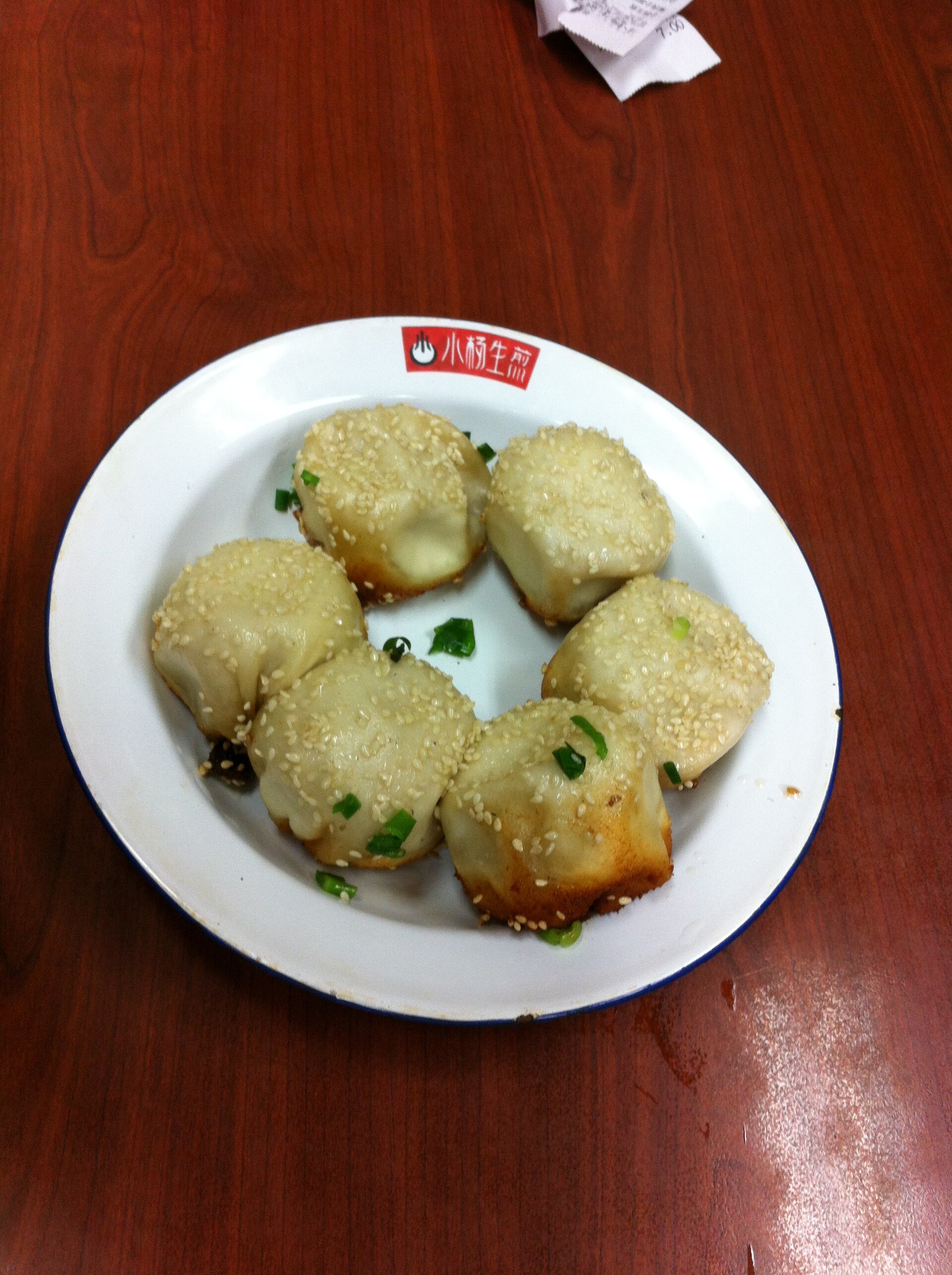 A basket of sheng jian bao, pan-fried pork buns, at a Shanghai shop