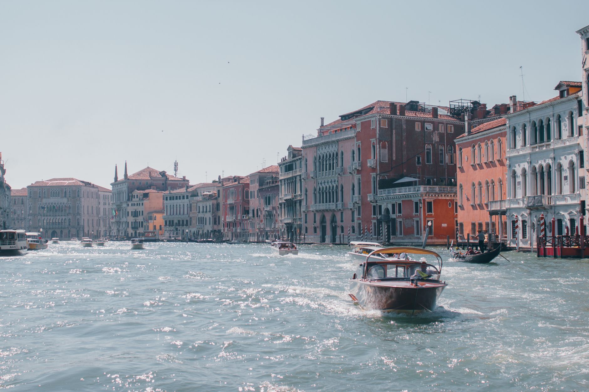 Motorboats cruising on the Grand Canal in Venice, Italy, with historic buildings lining the waterway