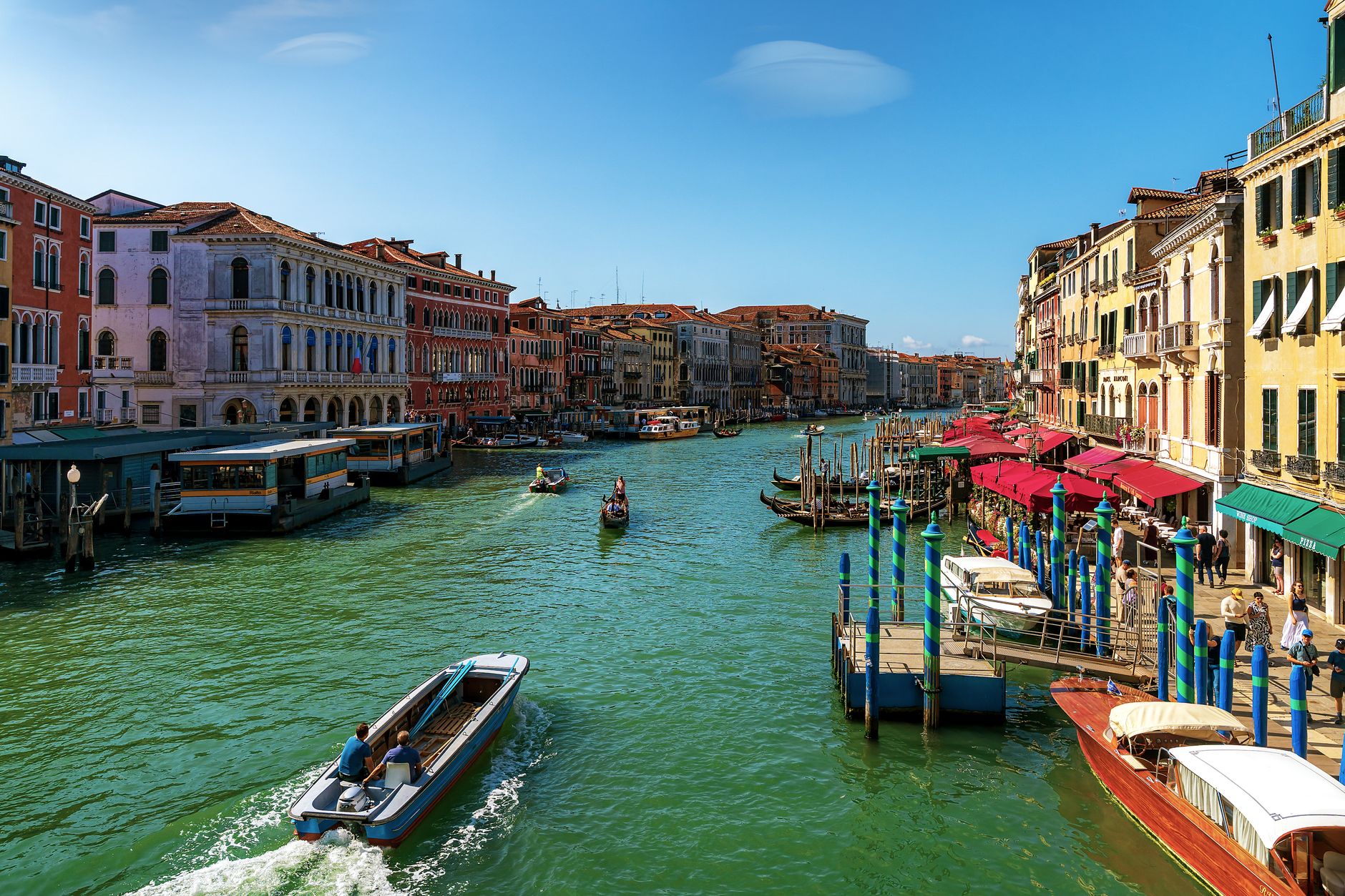 Grand Canal in Venice with buildings and boats under a clear blue sky