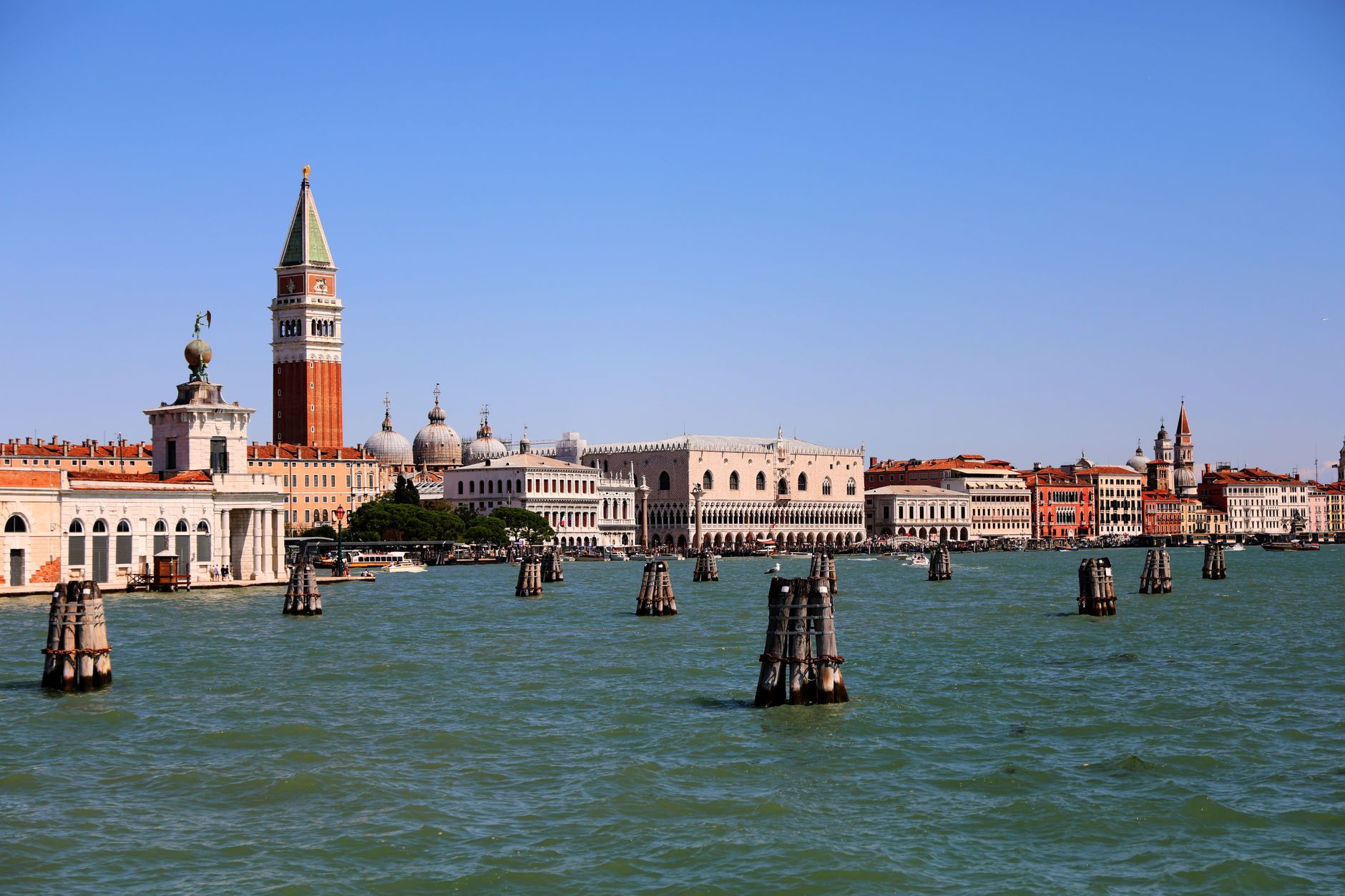 Venice's historic waterfront with St Mark's Campanile under a blue sky