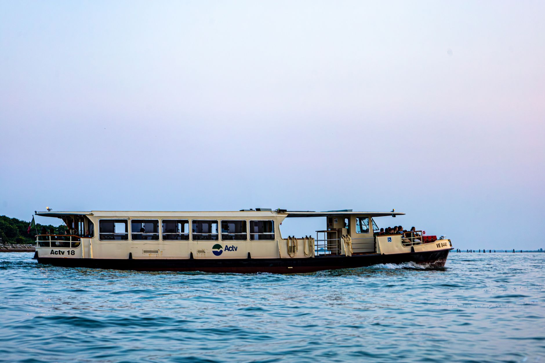 Public water bus cruising through the Venetian Lagoon during sunset in Venice, Italy