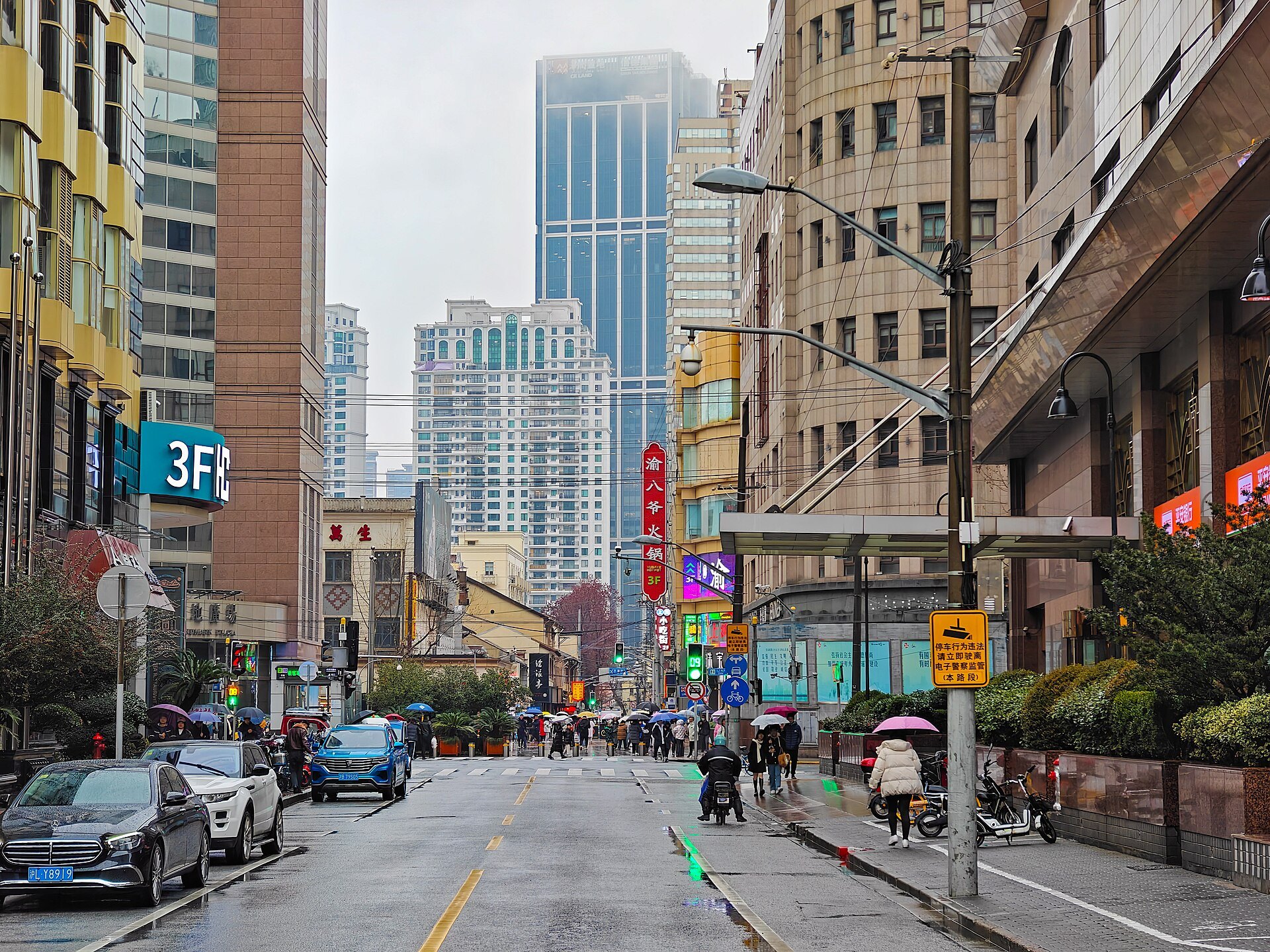 A busy street of shops and awnings on the Bund side of the river
