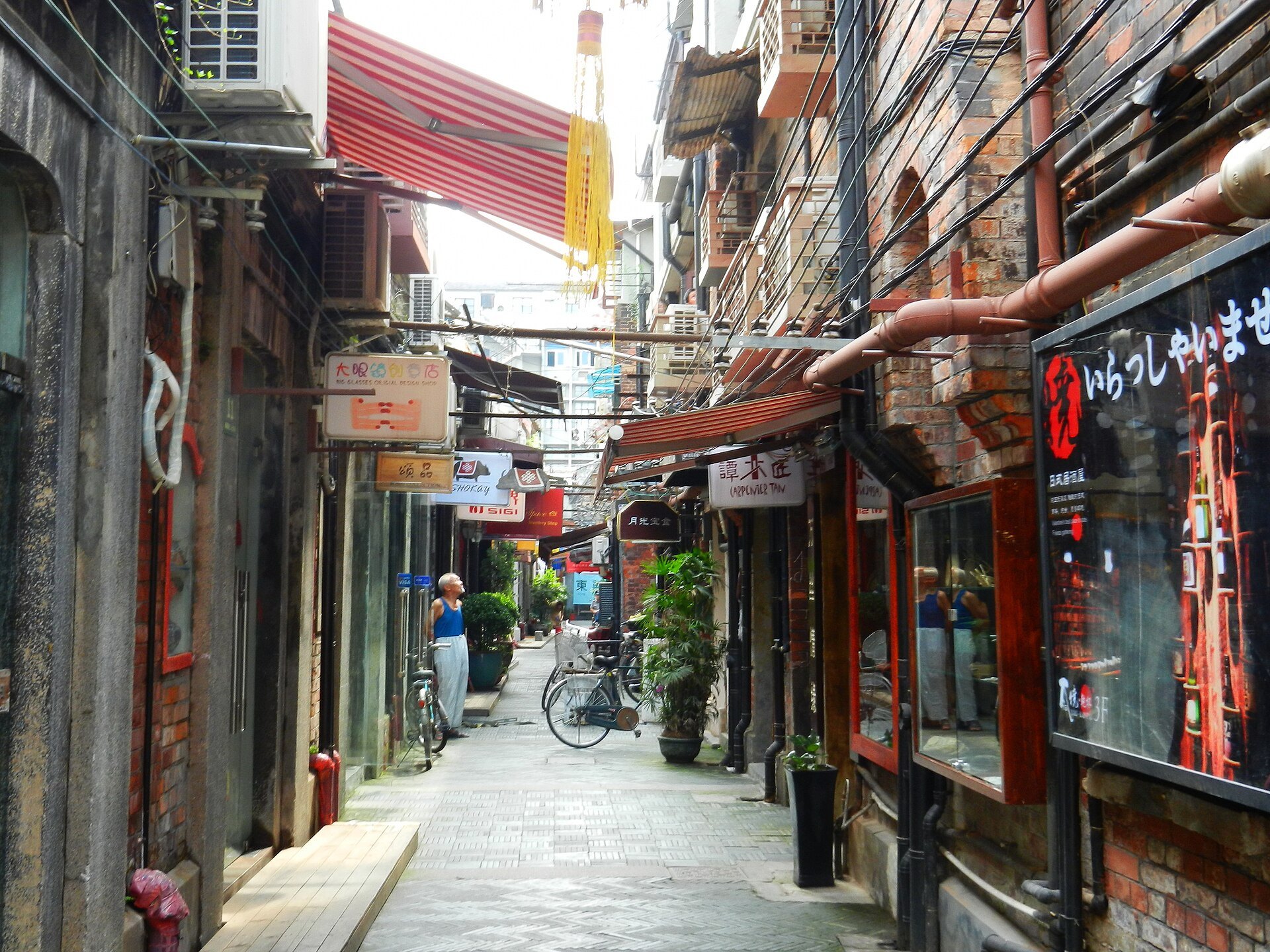 A lane in Tianzifang lined with small shops and hanging signs