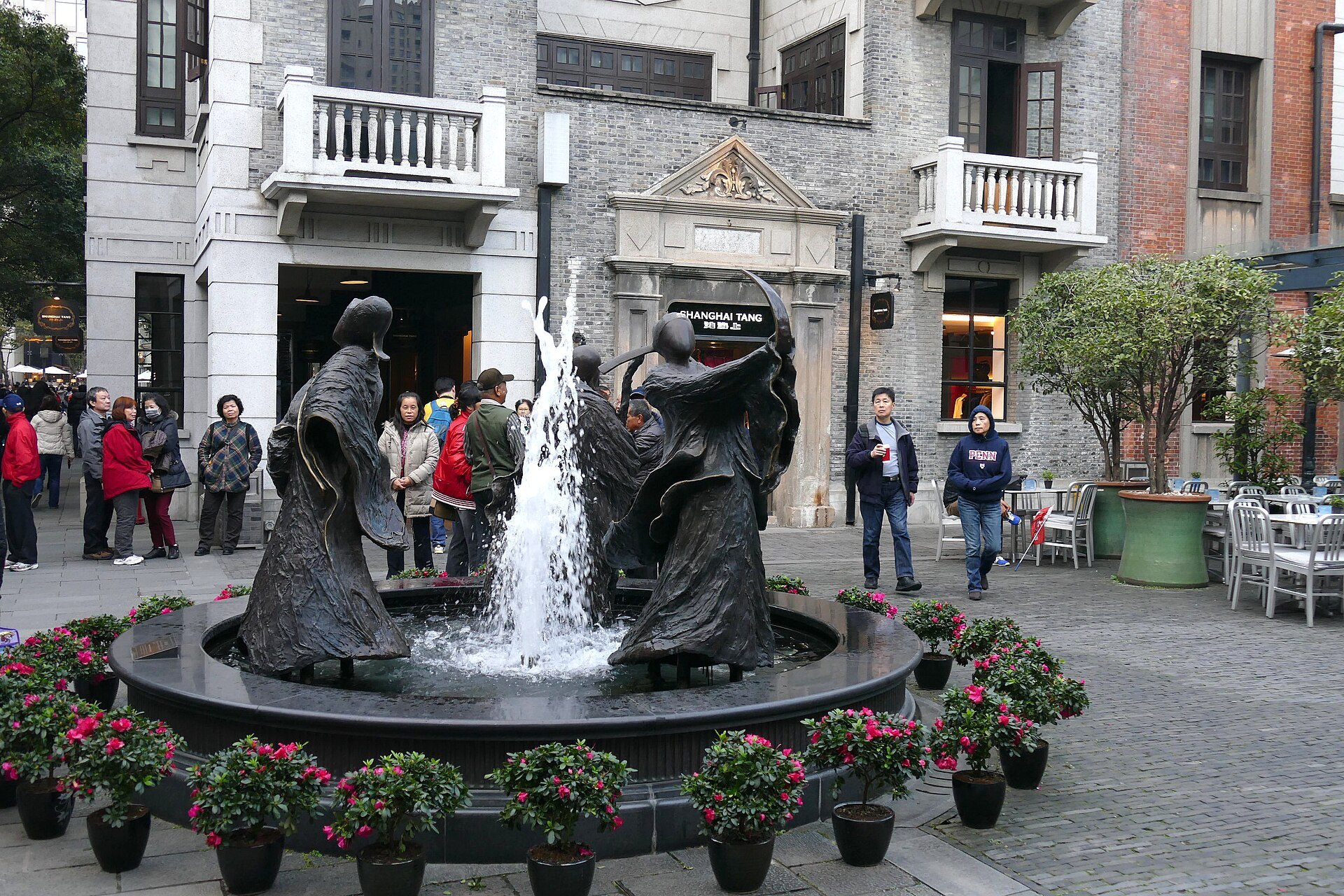 The fountain plaza at Xintiandi with bronze figures and visitors around it