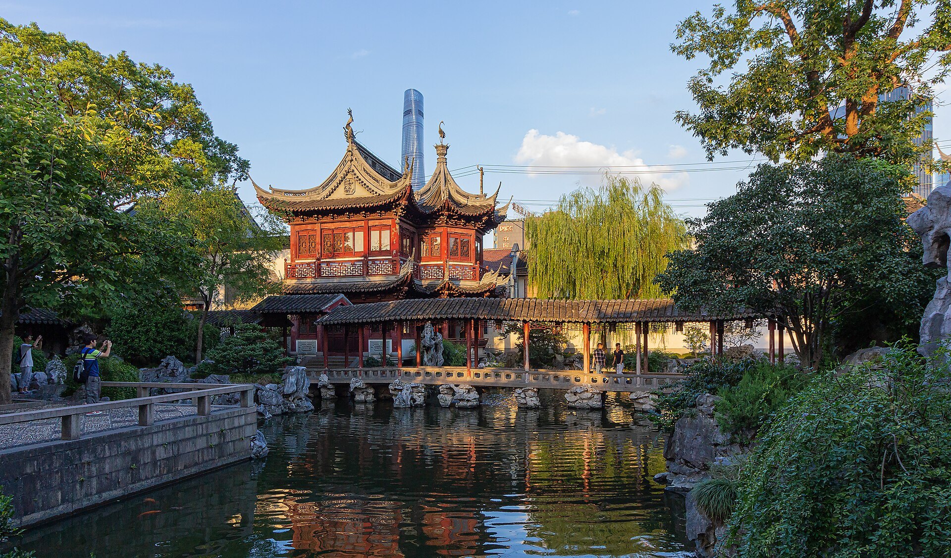 A pavilion with upswept eaves reflected in the garden's water